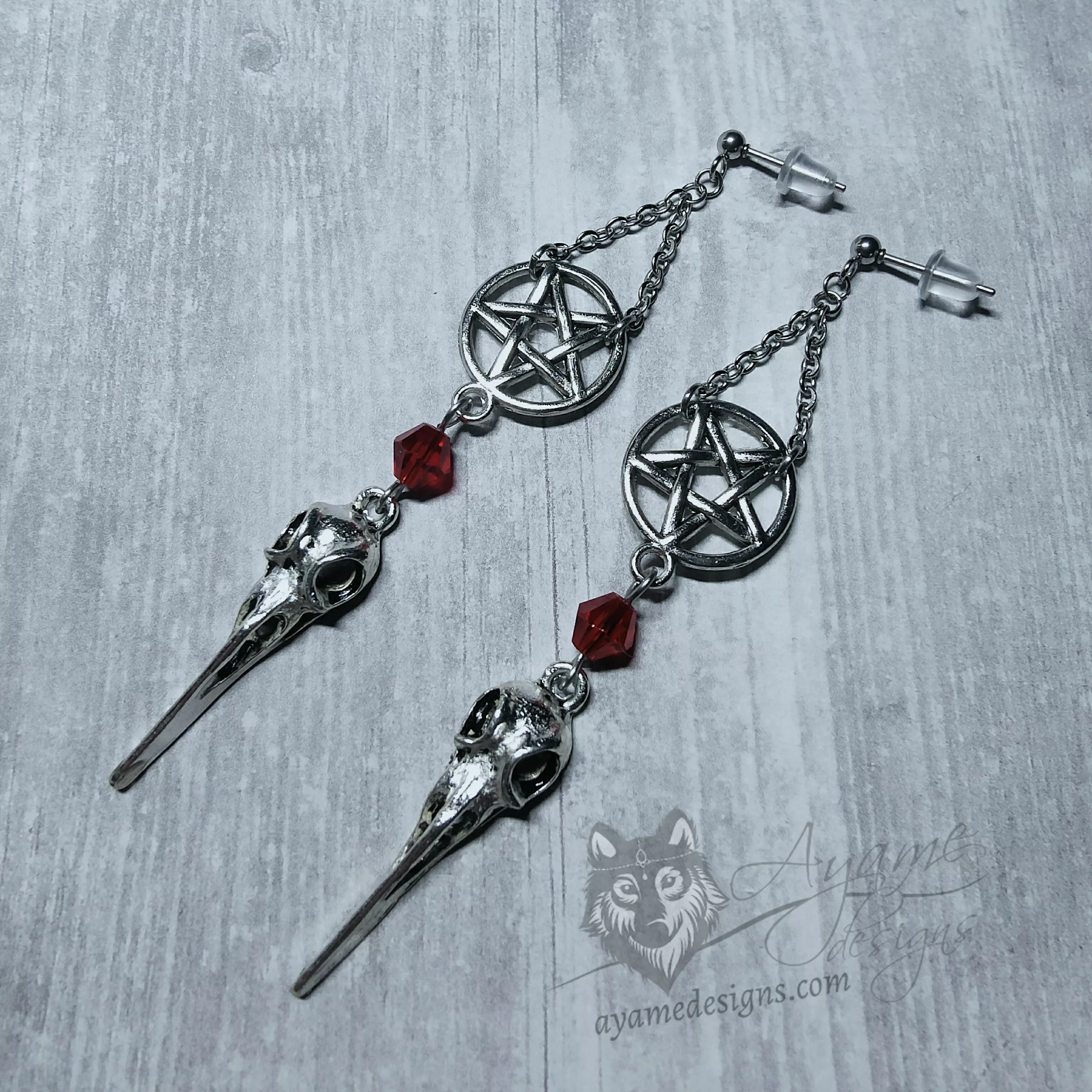Handmade gothic earrings with bird skull and inverted pentacle charms and red Austrian crystal beads on stainless steel earring studs