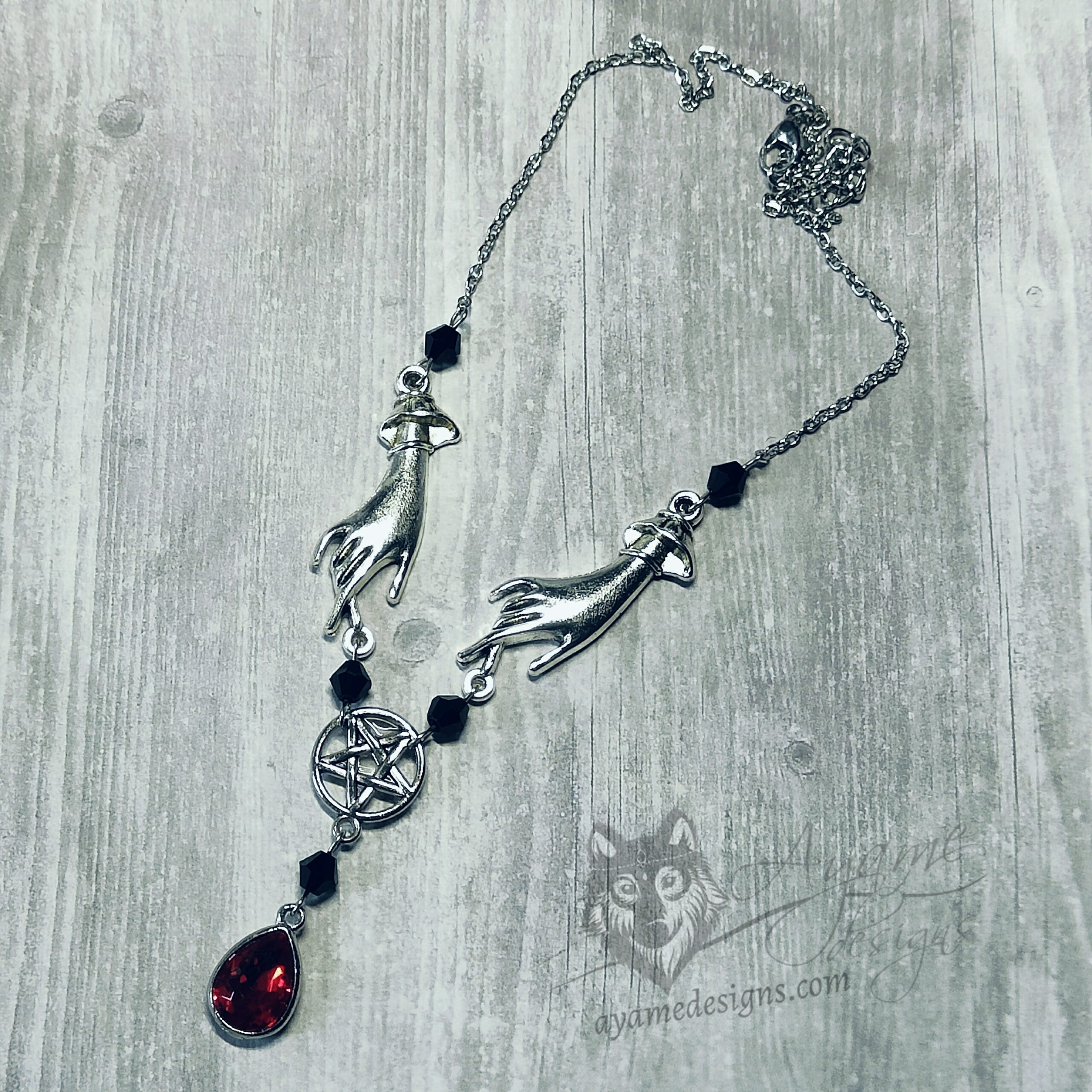 Adjustable necklace with hand pendants, a pentacle connector and a red teardrop charm