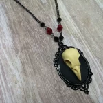 Handmade adjustable gothic necklace with a resin bird skull in a black filigree frame, black and red Austrian crystal beads and black stainless steel chain