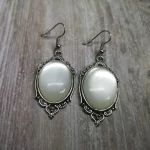 Elegant gothic earrings with white resin cabochons in silver filigree frames, on stainless steel earring hooks