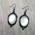 Elegant gothic earrings with white resin cabochons in black filigree frames, on stainless steel earring hooks