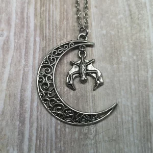necklace with a filigree moon and handing bat pendant on a stainless steel chain