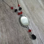 Handmade adjustable gothic necklace with a white resin cabochon in a silver filigree frame, black and red Austrian crystal beads and silver stainless steel chain
