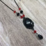 Handmade adjustable gothic necklace with a black resin cabochon in a black filigree frame, black and red Austrian crystal beads and black stainless steel chain