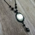 Handmade adjustable gothic necklace with a white resin cabochon in a black filigree frame, black Austrian crystal beads and black stainless steel chain