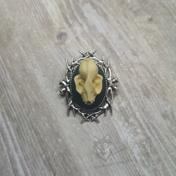 Small resin bat skull cameo brooch with a branch style frame