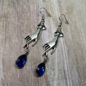 Elegant gothic earrings with hand charms and blue teardrop charms, on stainless steel earring hooks
