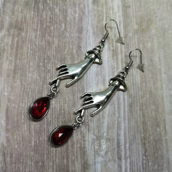 Elegant gothic earrings with hand charms and red teardrop charms, on stainless steel earring hooks