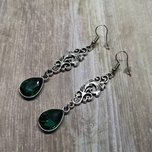 Elegant gothic earrings with filigree connectors and green teardrop charms, on stainless steel earring hooks