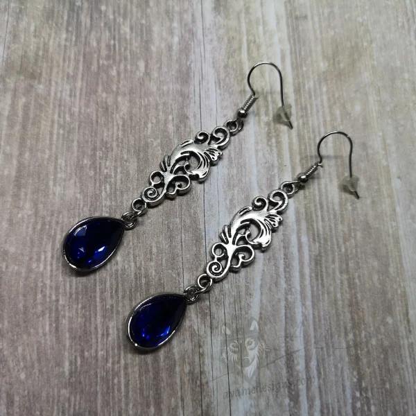 Elegant gothic earrings with filigree connectors and blue teardrop charms, on stainless steel earring hooks