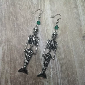 Handmade earrings with mermaid skeleton pendants and teal Austrian crystal beads on stainless steel earring hooks
