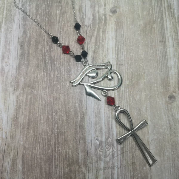Handmade Egyptian mythology necklace with an Eye Of Horus and ankh pendant, black and red Austrian crystal beads, and stainless steel chain