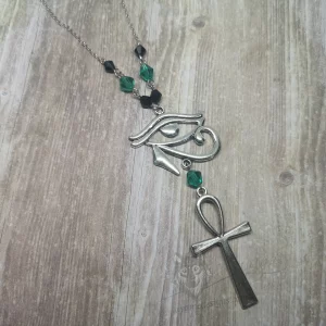 Handmade Egyptian mythology necklace with an Eye Of Horus and ankh pendant, black and teal Austrian crystal beads, and stainless steel chain