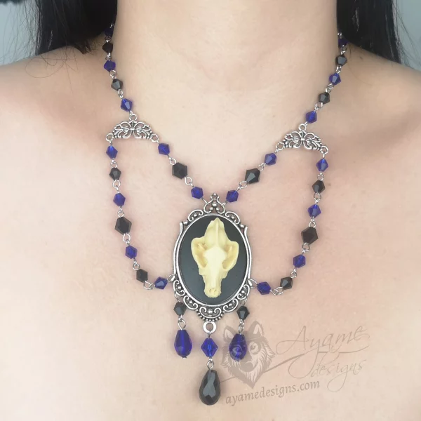 Handmade beaded choker necklace with a large resin wolf skull pendant in a filigree frame, and blue and black Austrian crystal beads