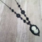 Handmade gothic necklace with a small resin Victorian cameo in a black filigree frame, purple and black Austrian crystal beads and black stainless steel chain