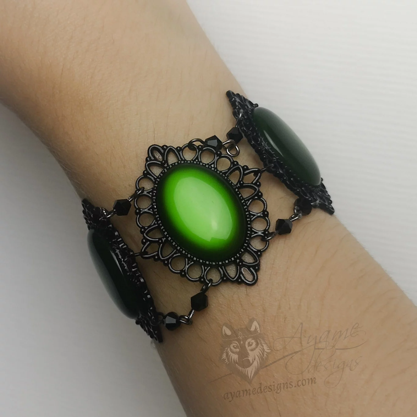 Handmade gothic bracelet with green resin cabochons in black filigree frames, and black Austrian crystal beads