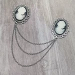 Collar pins with resin cameos in filigree frames, and 3 strands of silver chain