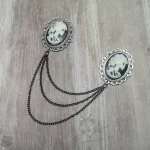 Collar pins with skeleton cameos in filigree frames, and 3 strands of black chain