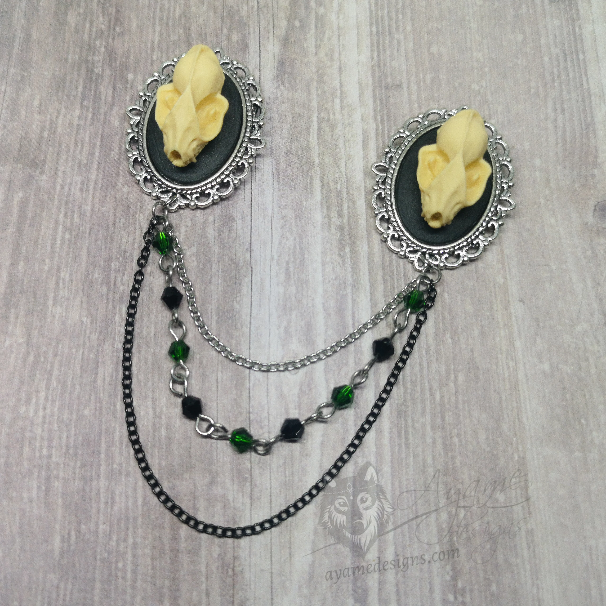 Collar pins with resin bat skulls in filigree frames, and 2 strands of chains and 1 strand of green and black Austrian crystal beads