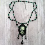 handmade adjustable Victorian gothic choker necklace with green Czech crystal and black Austrian crystal beads, and a glow in the dark skeleton cameo pendant in a black filigree frame