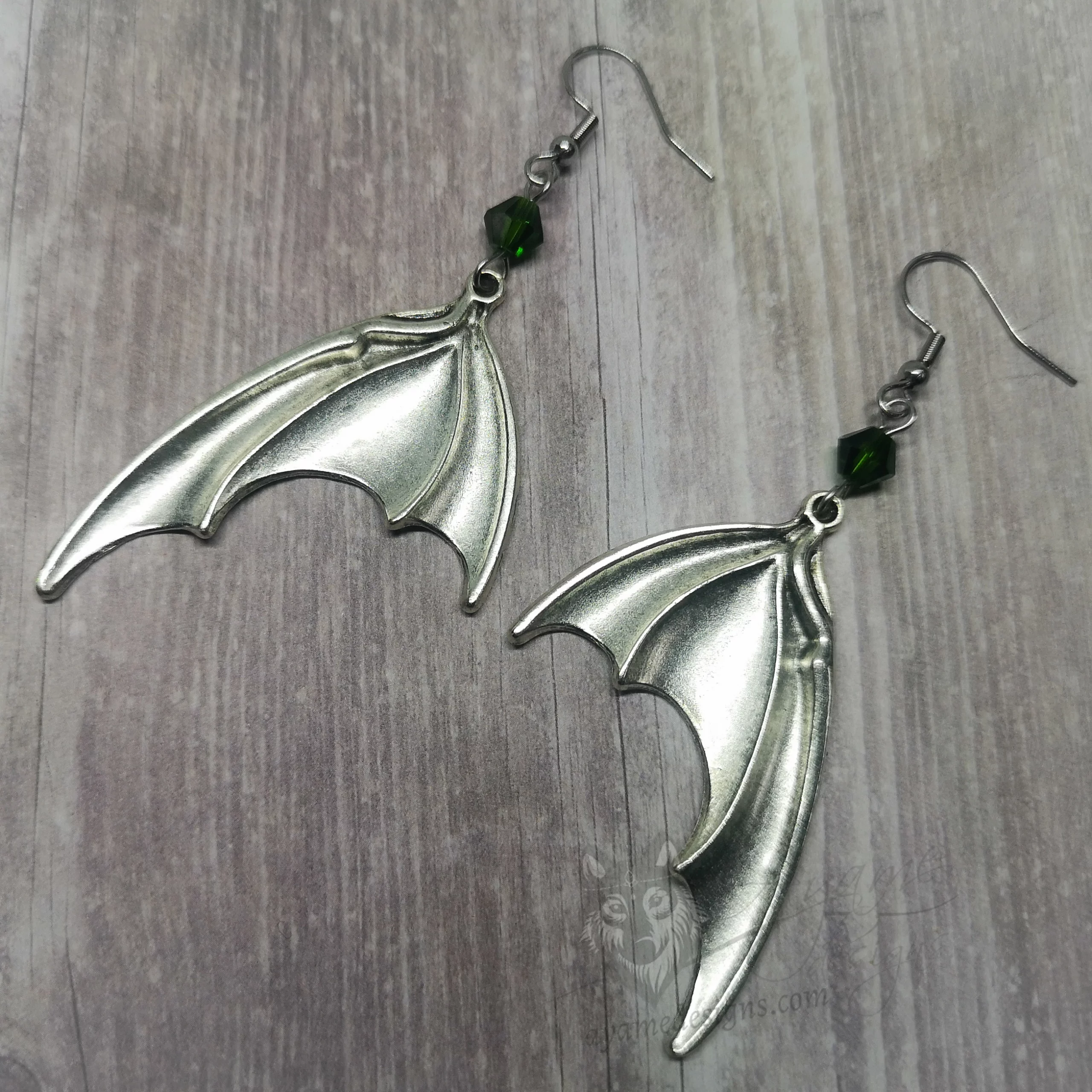 Handmade gothic earrings with large silver bat wings and green Austrian crystal beads on stainless steel earring hooks