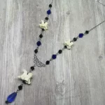 Handmade adjustable necklace with snake vertebrae, a filigree connector, black and blue Austrian crystal beads, and stainless steel chain