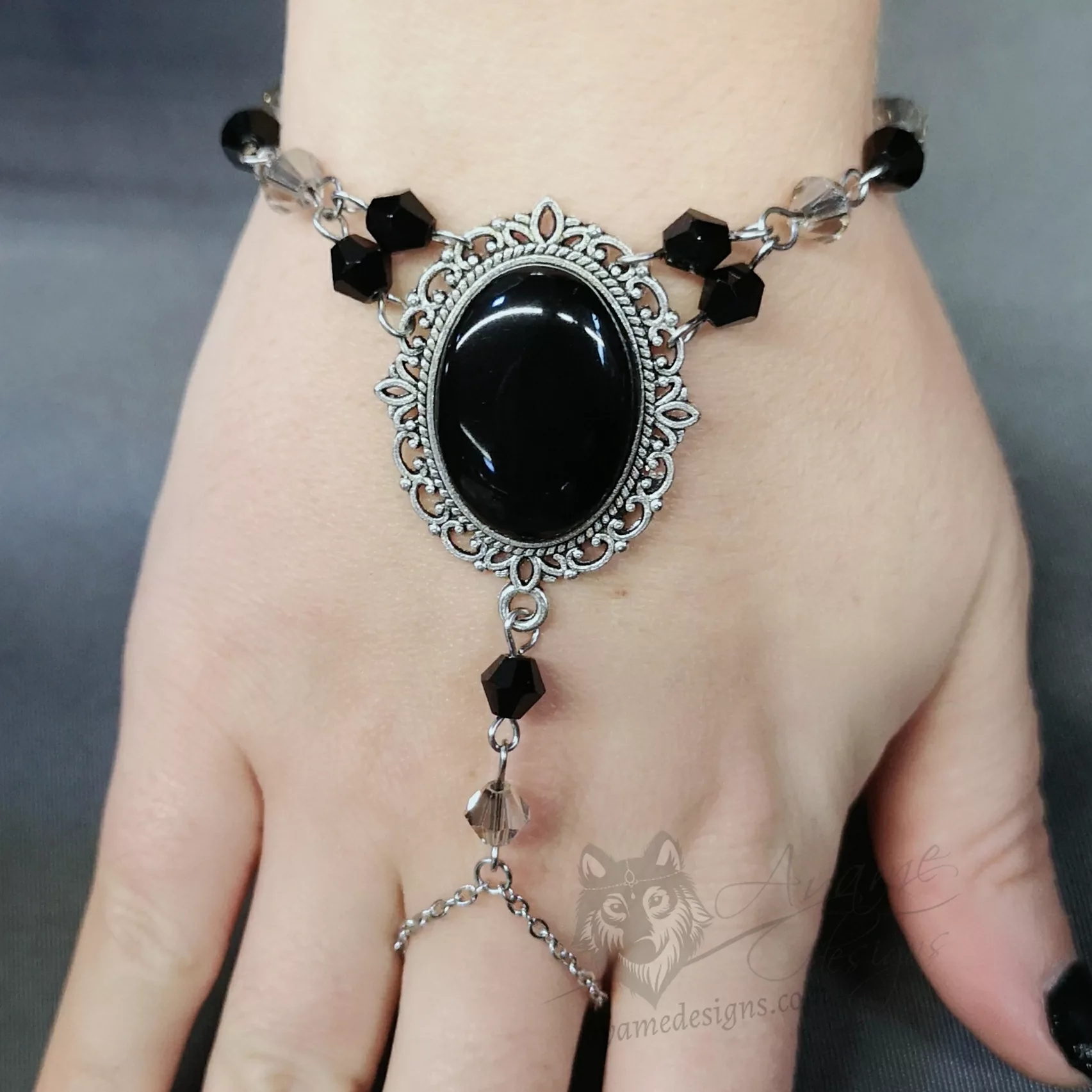 Handmade gothic bracelet with a black resin cabochon in a filigree frame, and black and grey Austrian crystal beads