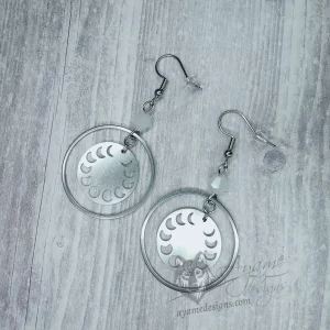 Handmade earrings with laser cut stainless steel moon phase charms inside stainless steel rings with white Austrian crystal beads, on stainless steel earring hooks