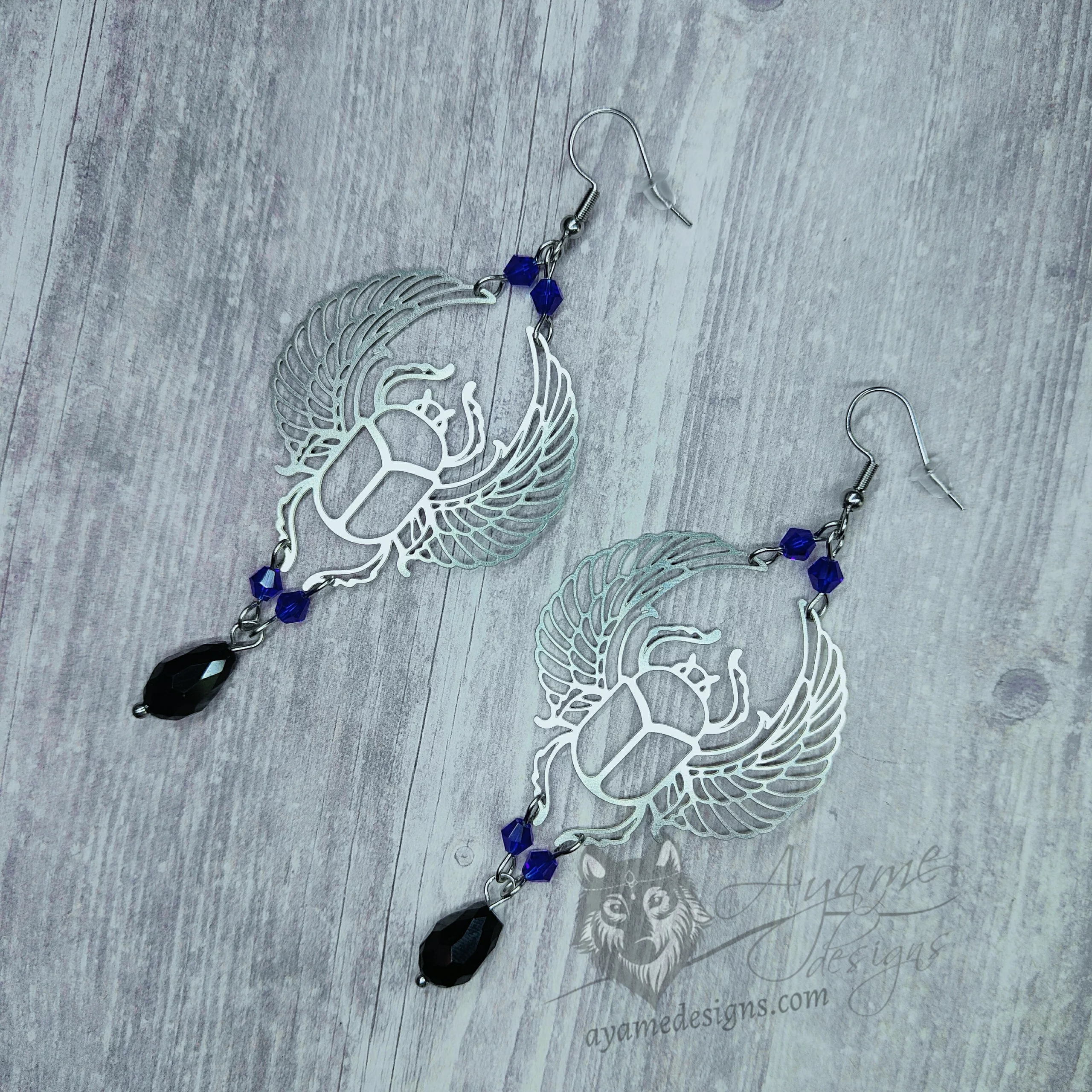 Handmade earrings with laser cut stainless steel scarab beetle charms with blue and black Austrian crystal beads, on stainless steel earring hooks