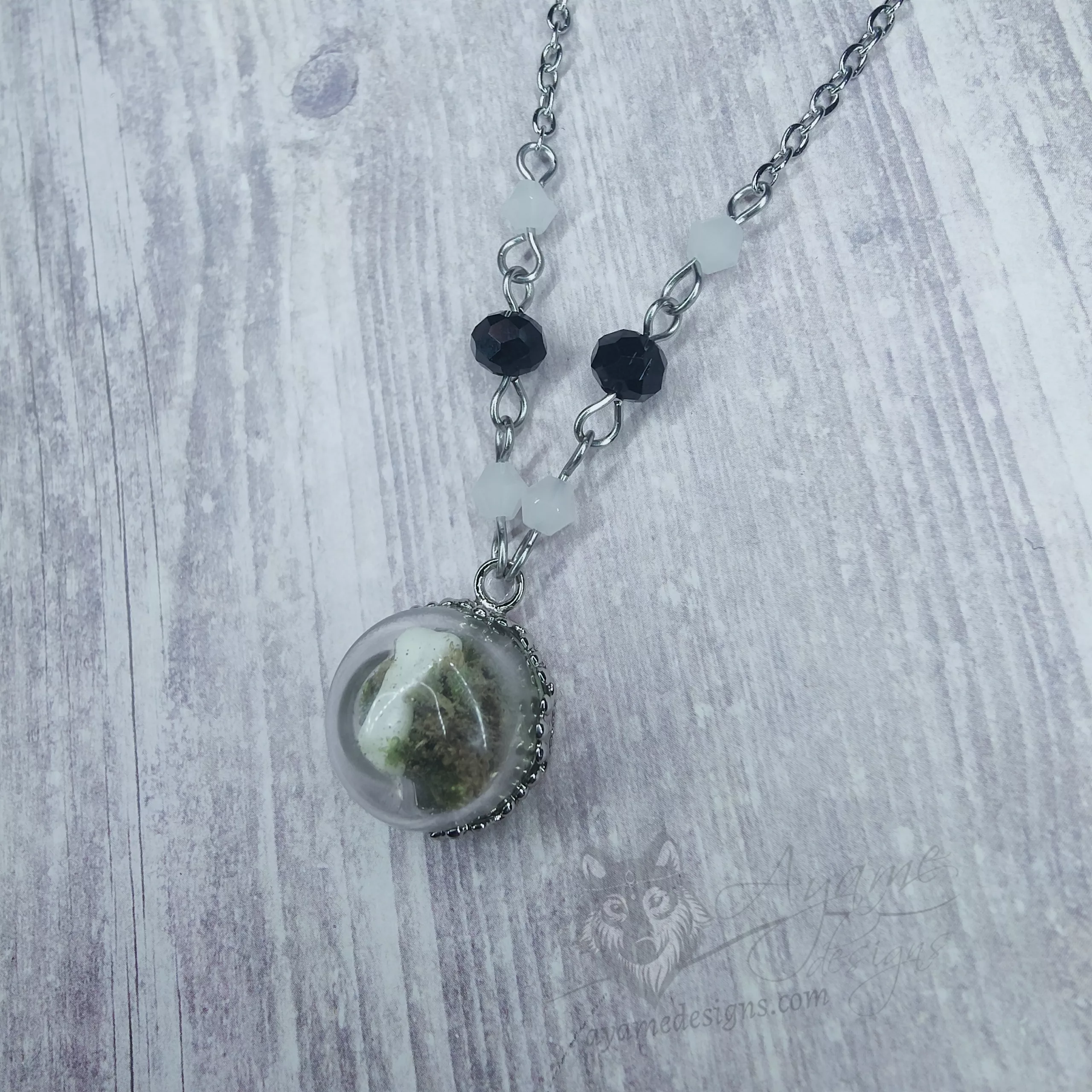 Glass dome necklace with ethically sourced snake vertebrae and moss, white and black Austrian crystal beads and stainless steel chain
