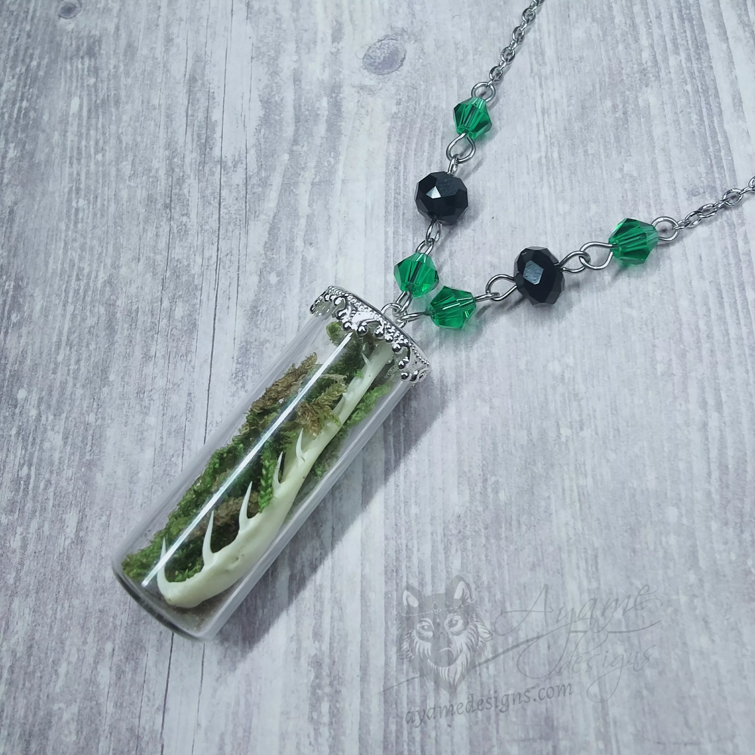 Glass vial necklace with ethically sourced snake vertebrae and moss, green and black Austrian crystal beads and stainless steel chain