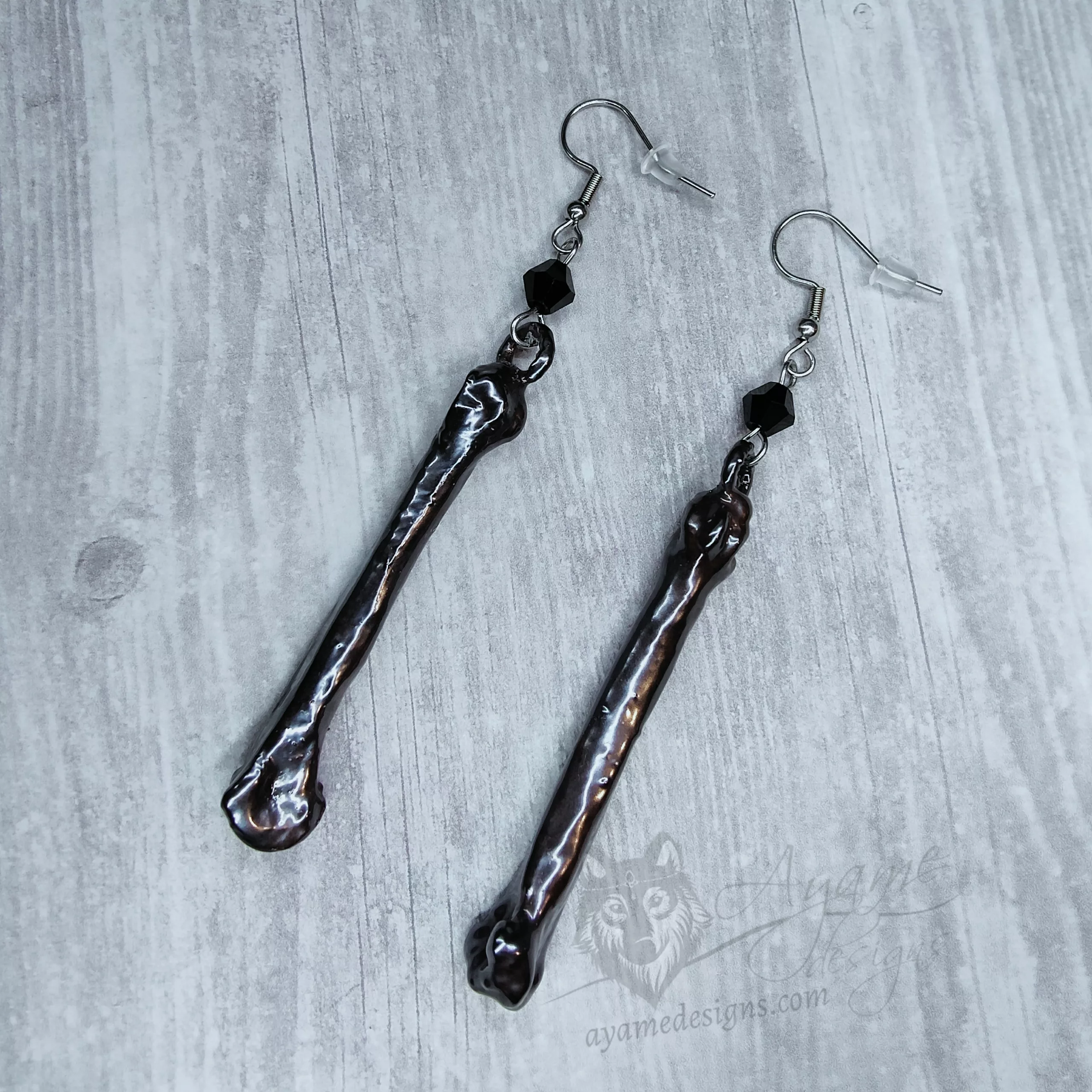 Handmade earrings made with real dog bones that have been electroformed (plated) with copper and given a gunmetal finish, with black Austrian crystal beads and stainless steel earring hooks