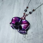 A necklace made with a real orchid plated (electroformed) in copper with a bright pink and purple finish, on a stainless steel chain
