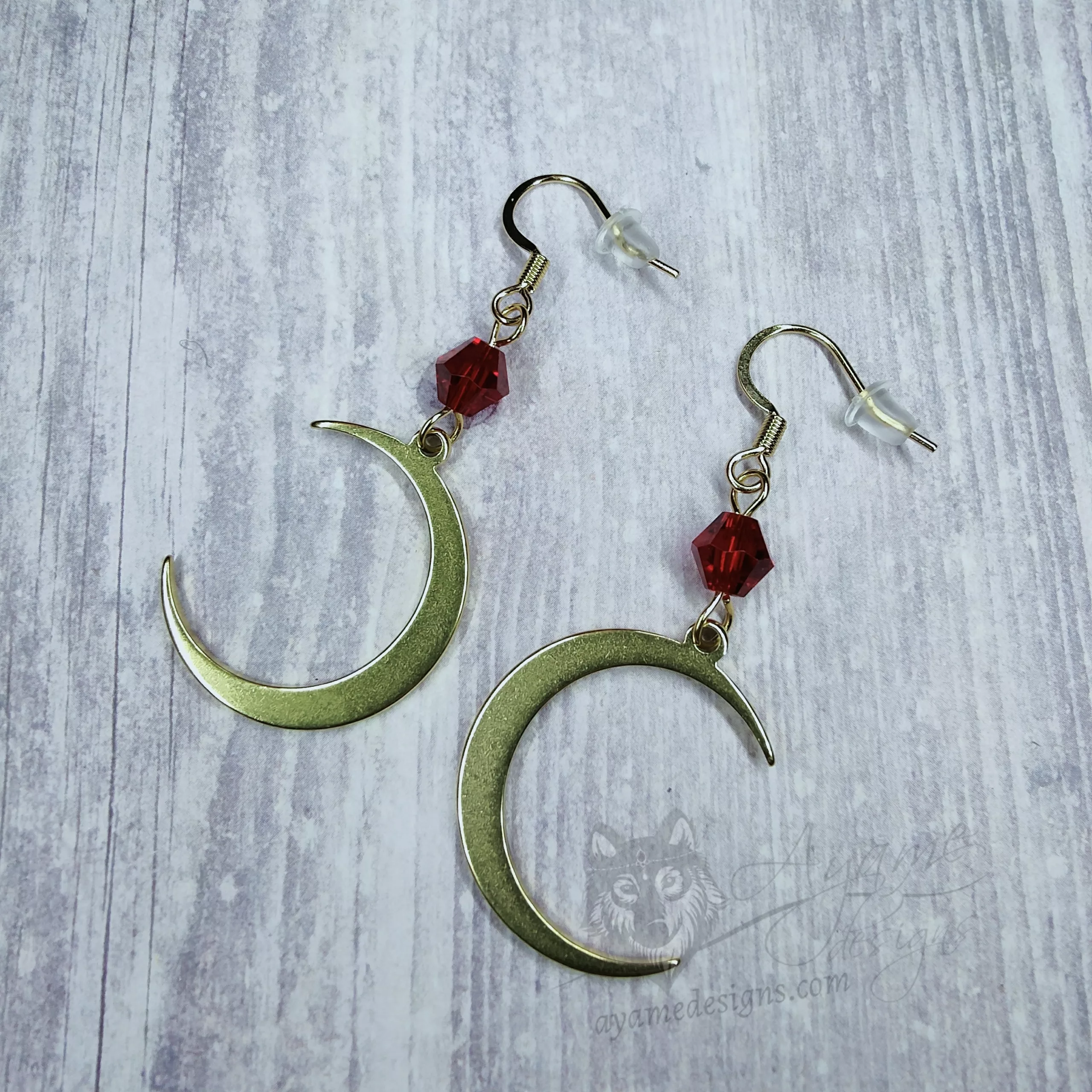 Handmade earrings with gold laser cut stainless steel moon charms with red Austrian crystal beads, on stainless steel earring hooks