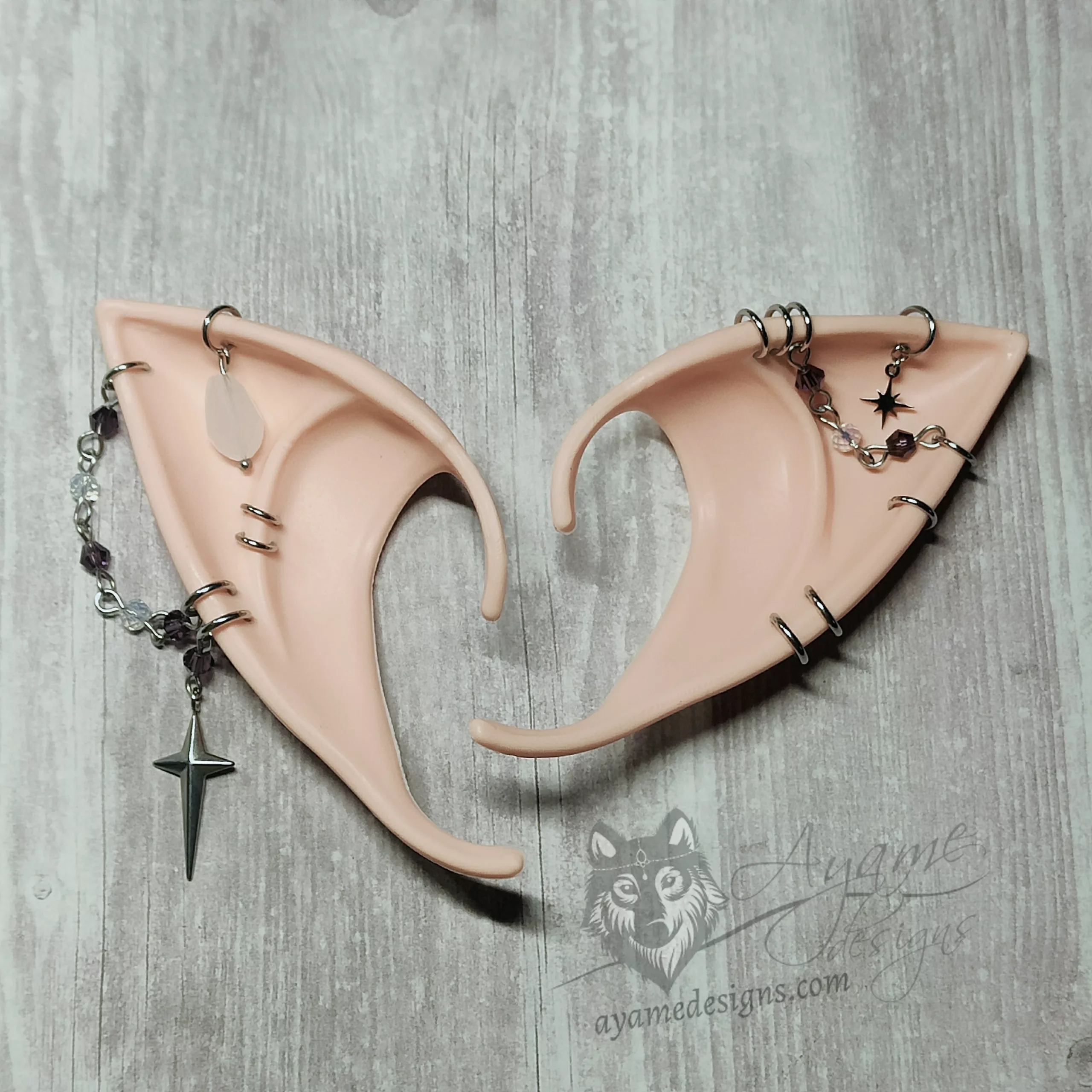 Pink tone beige elf ears with silver chains and rings, white and purple glass beads and star charms